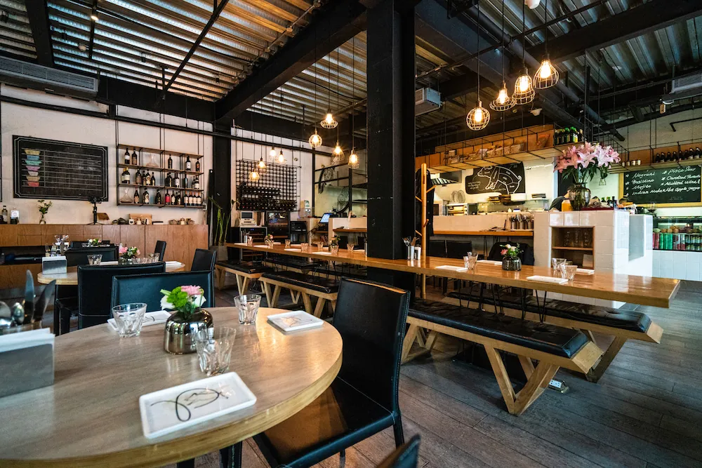 Moderan interijer restorana s metalnim konstrukcijama, šankom i namještajem po mjeri